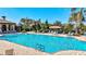 Gorgeous community pool with plenty of seating, palm trees, and open skies above at 351 Carlino Dr, Nokomis, FL 34275