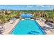 Beautiful community pool with many lounge chairs and a scenic lake view in the background at 351 Carlino Dr, Nokomis, FL 34275