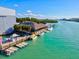 Aerial view of a waterfront restaurant with dock, boats, and open-air dining under a thatched roof on a sunny day at 351 Carlino Dr, Nokomis, FL 34275