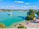 Scenic waterway view with boats, colorful kayaks, a beach area, and lush landscaping along the shoreline at 351 Carlino Dr, Nokomis, FL 34275