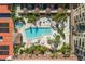 Aerial view showcasing a beautifully landscaped pool area with palm trees and lounge seating at 100 Central Ave # D509, Sarasota, FL 34236