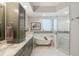 Luxurious bathroom featuring double vanity, a soaking tub, and a glass shower at 100 Central Ave # D509, Sarasota, FL 34236