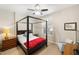 Bedroom with four-poster bed, neutral walls, ceiling fan and desk next to the shuttered window at 100 Central Ave # D509, Sarasota, FL 34236