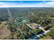 An aerial view shows the approximate property line of the acreage and house surrounded by lush greenery and neighborhood at 1358 Ewing St, Nokomis, FL 34275