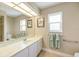 Bright bathroom featuring a mirrored vanity, two windows, and convenient towel bars at 1358 Ewing St, Nokomis, FL 34275