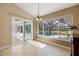 Bright dining area with tile floors, chandelier, and view of the pool and backyard through large windows and sliding doors at 1358 Ewing St, Nokomis, FL 34275