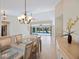 Formal dining room with glass top table and chairs, chandelier and access to the lanai at 1358 Ewing St, Nokomis, FL 34275