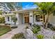 Charming single-story home entrance featuring a well-manicured lawn and lush landscaping at 1358 Ewing St, Nokomis, FL 34275