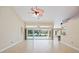 Open living room boasting neutral walls, tile flooring, and pool view through large sliding glass doors at 1358 Ewing St, Nokomis, FL 34275