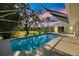 Screened-in pool with a clear view of a lush green yard and blue skies. Perfect for outdoor relaxation and entertainment at 1358 Ewing St, Nokomis, FL 34275