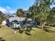 View of the rear of the home with a screened in lanai overlooking the pool and lush backyard at 1358 Ewing St, Nokomis, FL 34275