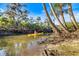 A kayaker paddles down the river, lined with lush vegetation and showcasing the outdoor lifestyle at 1358 Ewing St, Nokomis, FL 34275