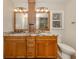 Bathroom featuring granite counters, double sinks and vanity, and wood cabinets at 17 Brentwood Ln, Englewood, FL 34223