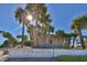 Stunning view of the Manasota Beach entrance, surrounded by lush palms and clear blue skies on a sunny day at 17 Brentwood Ln, Englewood, FL 34223