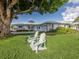 Landscaped front yard featuring two Adirondack chairs, green grass, and a view of the single-story home at 17 Brentwood Ln, Englewood, FL 34223