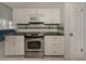 A well-lit kitchen featuring stainless steel appliances and white cabinetry at 17 Brentwood Ln, Englewood, FL 34223