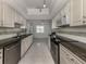 Galley kitchen featuring stainless steel appliances, granite countertops, and white cabinetry at 17 Brentwood Ln, Englewood, FL 34223