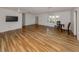 Open-concept living room with hardwood floors, ceiling fans, and natural light from windows with shutters at 17 Brentwood Ln, Englewood, FL 34223