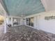 Covered patio with tile flooring, white pillars, ceiling fan, and sliding glass doors leading to interior spaces at 17 Brentwood Ln, Englewood, FL 34223