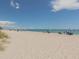 Expansive sandy beach with beachgoers relaxing under umbrellas on a sunny day near the ocean at 17 Brentwood Ln, Englewood, FL 34223