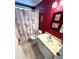 Bathroom with a floral shower curtain, bright red walls, and vanity with sink at 210 Schooner St, North Port, FL 34287