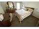 Inviting bedroom with a patterned bedspread, dresser, and desk area near a window at 210 Schooner St, North Port, FL 34287