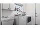 This laundry room features a washer, dryer, sink, and upper cabinets at 2537 Northway Dr, Venice, FL 34292