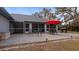 Rear patio with a red umbrella, grill, and outdoor seating, accessible via sliding glass doors and screened-in enclosure at 2537 Northway Dr, Venice, FL 34292