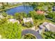 Aerial view of home with lush landscaping, circular drive, and pond in a lakeside community at 3 Inlets Blvd # 3, Nokomis, FL 34275