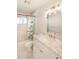 Bathroom with marble vanity, decorative lighting, and tiled tub and shower at 3 Inlets Blvd # 3, Nokomis, FL 34275