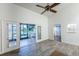 Bright room features wood-look floors, a ceiling fan, and access to outdoor patio with lake view at 3 Inlets Blvd # 3, Nokomis, FL 34275