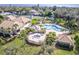 Aerial view of community pool and spa surrounded by tropical landscaping and tennis courts on a sunny day at 3 Inlets Blvd # 3, Nokomis, FL 34275