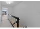 Bright hallway with black and white stair railing leading to a view of the outdoor balcony at 3351 Ramblewood Ct # 3351, Sarasota, FL 34237