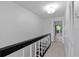 Bright hallway with black and white stair railing leading to a view of the outdoor balcony at 3351 Ramblewood Ct # 3351, Sarasota, FL 34237