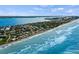 A stunning aerial view of beachfront homes along a picturesque shoreline with rolling waves at 4074 N Beach Rd, Englewood, FL 34223