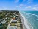 Aerial view of the beachfront property with ocean views and a blue sky at 4074 N Beach Rd, Englewood, FL 34223