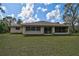 A well manicured backyard featuring sliding glass doors and a screened in porch at 4344 Ozark Ave, North Port, FL 34287