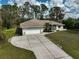 Charming home featuring a two-car garage, screen door entrance, and lush landscaping at 4344 Ozark Ave, North Port, FL 34287