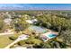 Aerial view showcasing community amenities, tennis courts, bocce ball court, pool, and lush landscaping at 446 Pendleton Ct, Venice, FL 34292