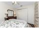 Bright bedroom showcasing a dresser with lamps and mirror, and a sliding door closet at 446 Pendleton Ct, Venice, FL 34292