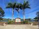 Community sign for Chestnut Creek featuring lush landscaping and a serene lake in the background at 446 Pendleton Ct, Venice, FL 34292