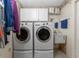 A convenient laundry room features stacked washer and dryer, with cabinets and a sink for added functionality at 446 Pendleton Ct, Venice, FL 34292