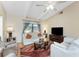 Living room with vaulted ceiling, wood laminate flooring, and neutral color palette at 446 Pendleton Ct, Venice, FL 34292