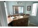 Bathroom featuring vanity with granite countertop, decorative mirror and window at 473 Sharks Pt, North Port, FL 34287