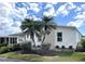 Beautiful single-story home featuring white siding, manicured lawn and decorative palm trees at 473 Sharks Pt, North Port, FL 34287