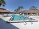 Community pool featuring clear blue water, safety railings and lounge chairs for residents at 473 Sharks Pt, North Port, FL 34287