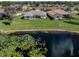 Aerial view of the property backing to a pond with fountain and lush landscaping at 5071 Winter Rose Way, Venice, FL 34293