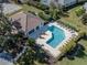 Aerial view of community pool with a sun deck, perfect for relaxing, and meticulously maintained landscaping at 5071 Winter Rose Way, Venice, FL 34293