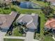 Aerial view of a well-manicured home with a pond in a residential neighborhood at 5071 Winter Rose Way, Venice, FL 34293