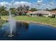 Water view home featuring lush lawn, mature landscaping, and fountain view at 5071 Winter Rose Way, Venice, FL 34293